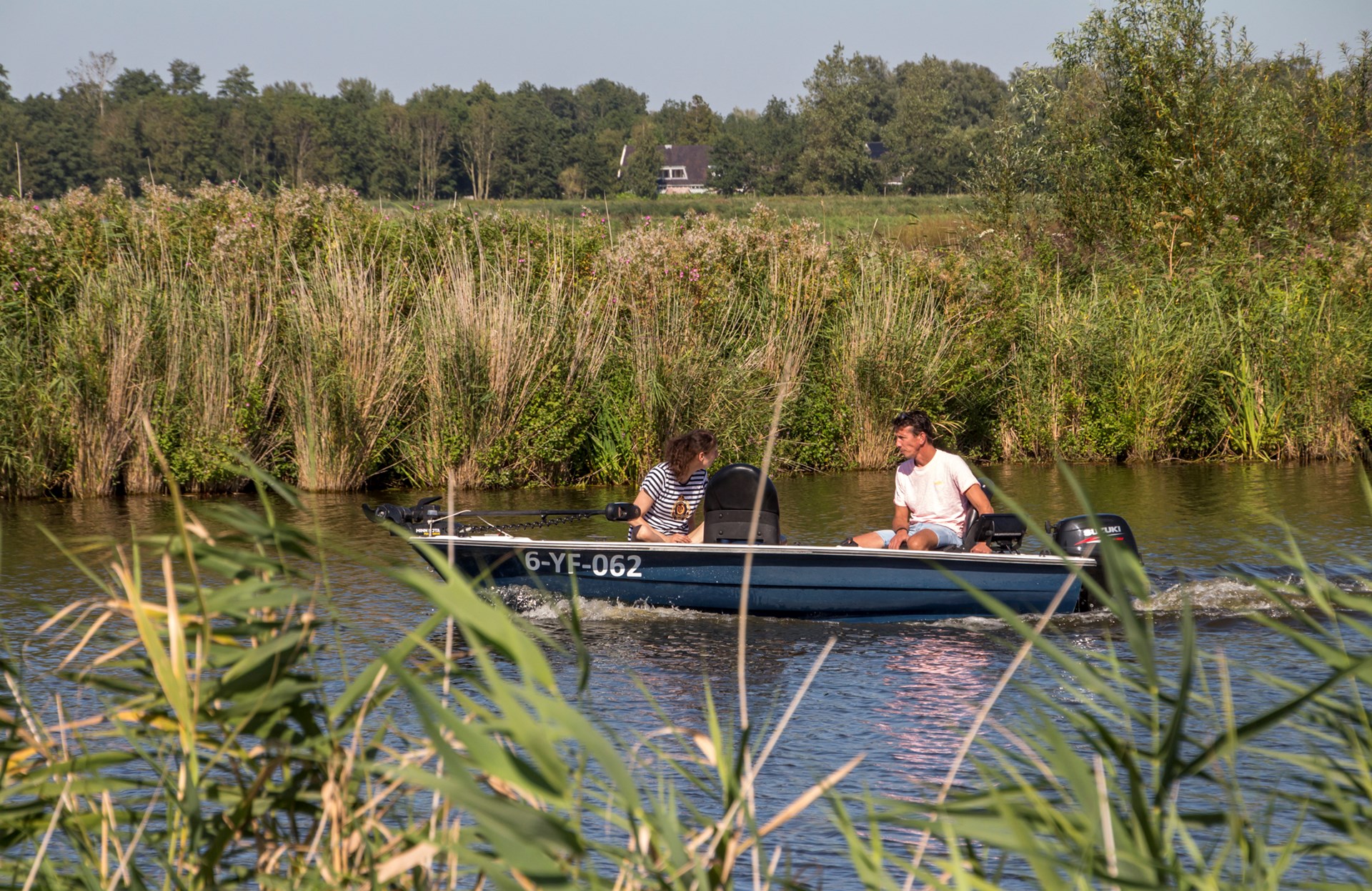 Een stel in een bootje op het water in Langedijk.